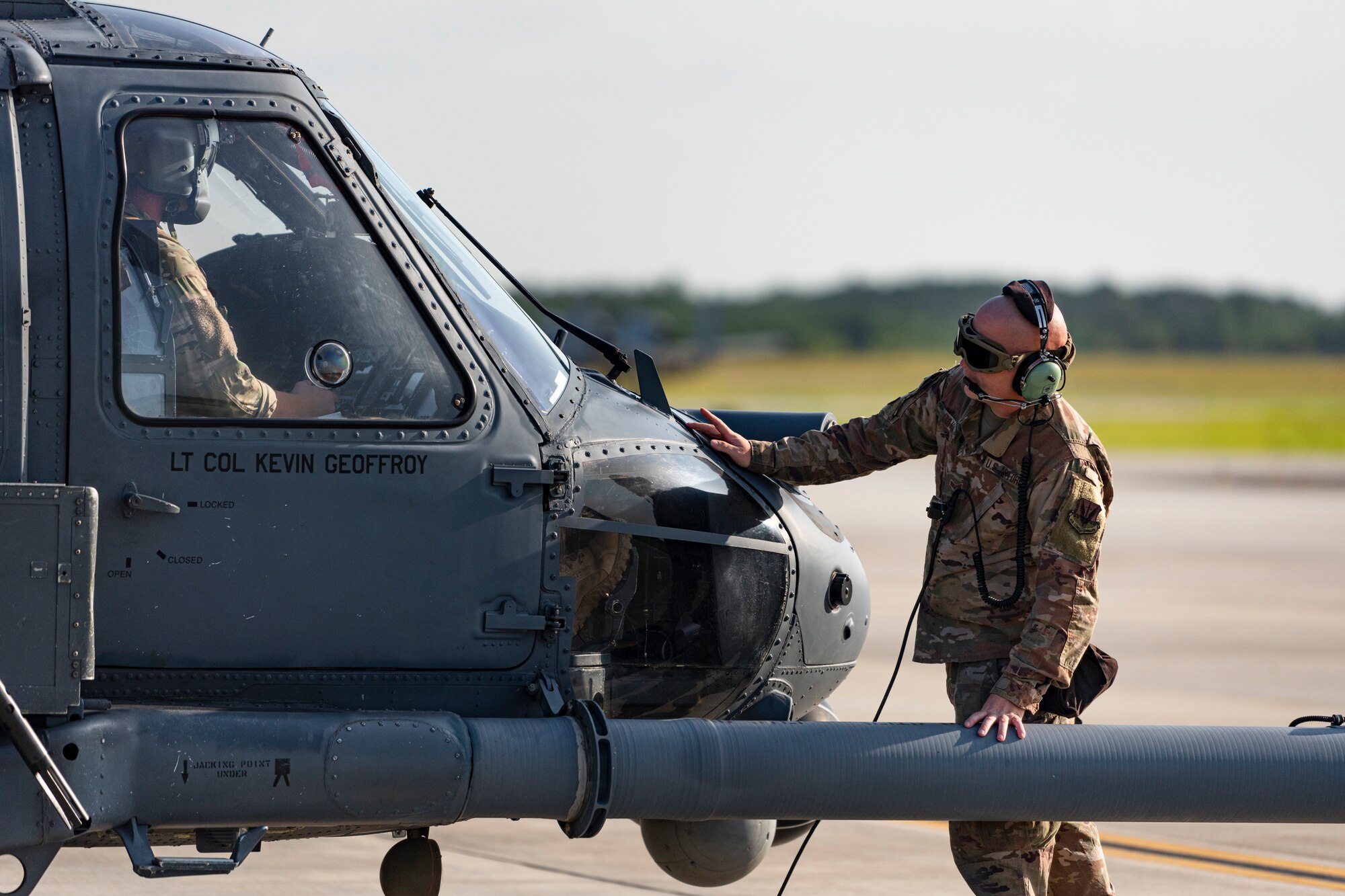 A photo of an Airman looking over a helicopter before a flight