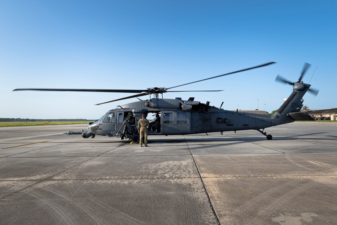 A photo of an Airman looking over a helicopter before a flight