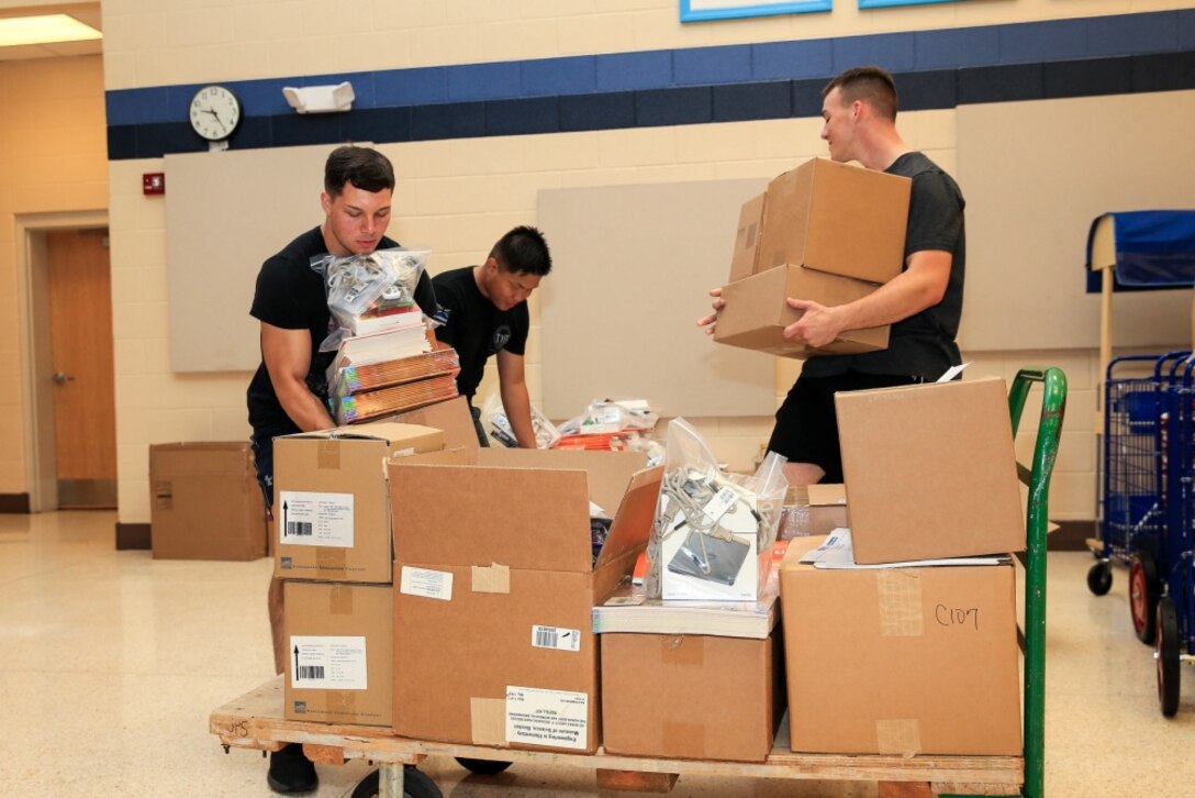 U.S. Marines with Headquarters Battery, 10th Marine Regiment, 2d Marine Division, load school supplies onto a cart during a unit function at Johnson Primary School on Camp Lejeune, North Carolina, July 31, 2020. The Marines assisted teachers in preparation for the coming school year by setting up classrooms, sanitizing, cleaning and maintaining the school grounds. Students will return to Johnson Primary School this August for the first time since the COVID-19 pandemic. (U.S. Marine Corps photo by Cpl. Elijah J. Abernathy)