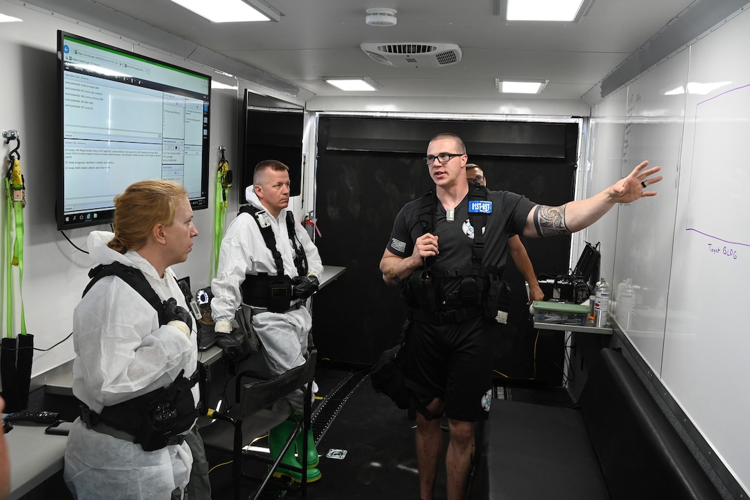 Three N.D. National Guard members gather in a trailer for a briefing prior to conducting a simulated search for radioactive material during Exercise Vigilant Guard at the North Dakota Air National Guard Base, Fargo, N.D., Aug. 4, 2020.