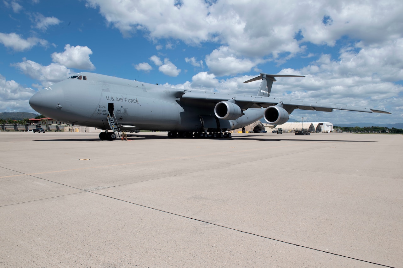 A C-5B transport jet sits on a flight line.