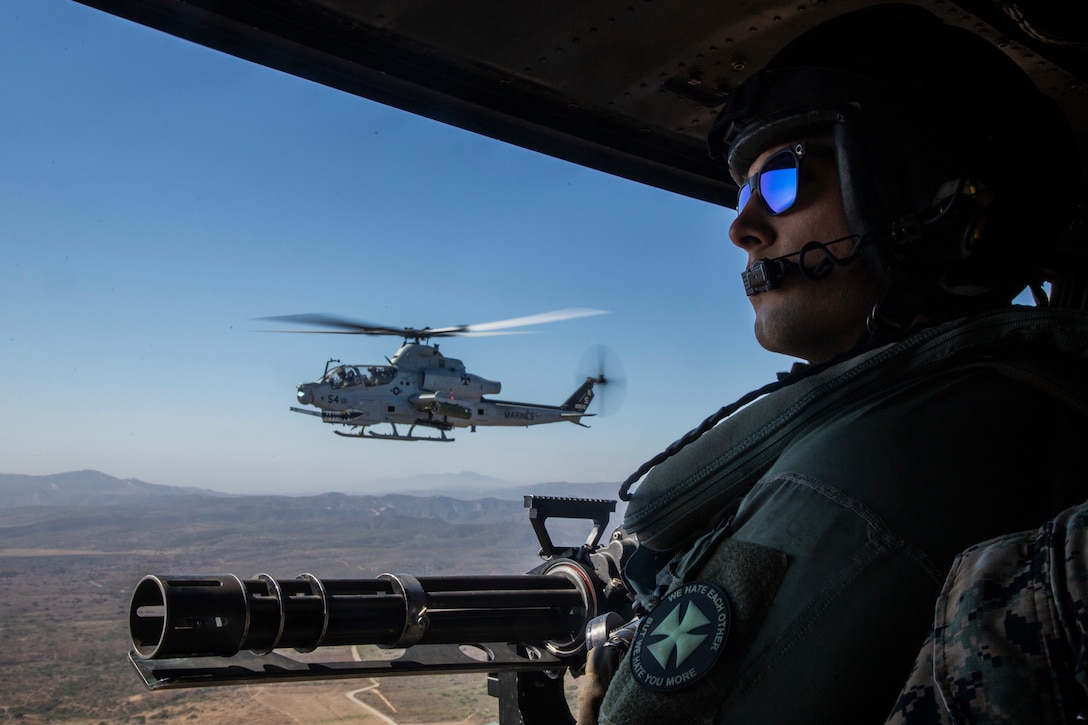 A man flying in a helicopter looks forward.