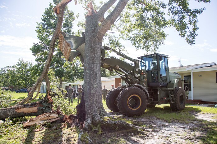 U.S. Marine Corps Lance Cpl. Anderson Rojas, an engineer equipment operator with 8th Engineer Support Battalion, 2nd Marine Logistics Group, clears debris at Berkeley Manor on Marine Corps Base Camp Lejeune, North Carolina, Aug. 4, 2020. U.S. Marines carried out recovery efforts after Hurricane Isaias in order to resume normal operations while following COVID-19 mitigation guidelines. (U.S. Marine Corps Photo by Lance Cpl. Isaiah Gomez)