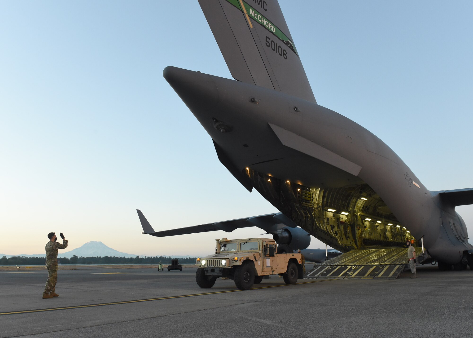 Staff Sgt. Christopher Krueger, 4th Airlift Squadron loadmaster, marshals a Humvee onto a C-17 Globemaster III, on Joint Base Lewis-McChord, Wash., Aug. 4, 2020. As part of Exercise Rainier War, many air crews over the course of a week practiced loading and off-loading to identify aspects that may need attention to be better prepared in an active combat scenario. (U.S. Air Force photo by Airman 1st Class Mikayla Heineck)