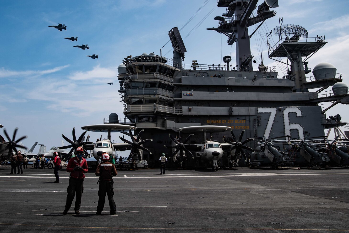 PACIFIC OCEAN (Aug. 5, 2020) Aircraft fly in formation over the Navy’s only forward-deployed aircraft carrier USS Ronald Reagan (CVN 76). Ronald Reagan, the flagship of Carrier Strike Group 5, provides a combat-ready force that protects and defends the United States, as well as the collective maritime interests of its allies and partners in the Indo-Pacific region. (U.S. Navy photo by Mass Communication Specialist 3rd Class Jason Tarleton)