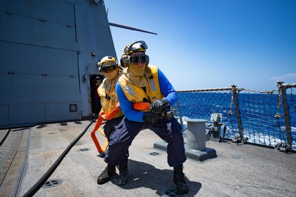 A hose team puts out a simulated fire in a damage control training scenario on the flight deck of the guided-missile destroyer USS Winston S. Churchill (DDG 81).