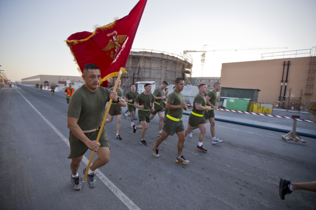 U.S. Marine Corps Sgt. Maj. Mario A. Marquez, sergeant major, Command Element Marine Forces Central Command Forward, runs with the unit colors during a command run on Naval Support Activity Bahrain Jan. 22, 2015. The run was conducted to boost morale and build camaraderie within the unit. (U.S. Marine Corps photo by CE MARFOR CENTCOM FWD Cpl. Sean Searfus/ Released)