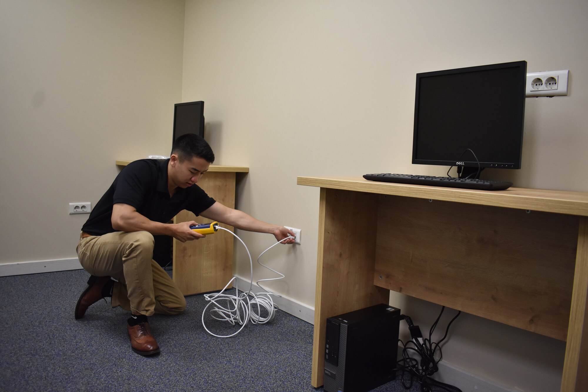 Photo of Airman setting up computer equipment for a National Testing Center