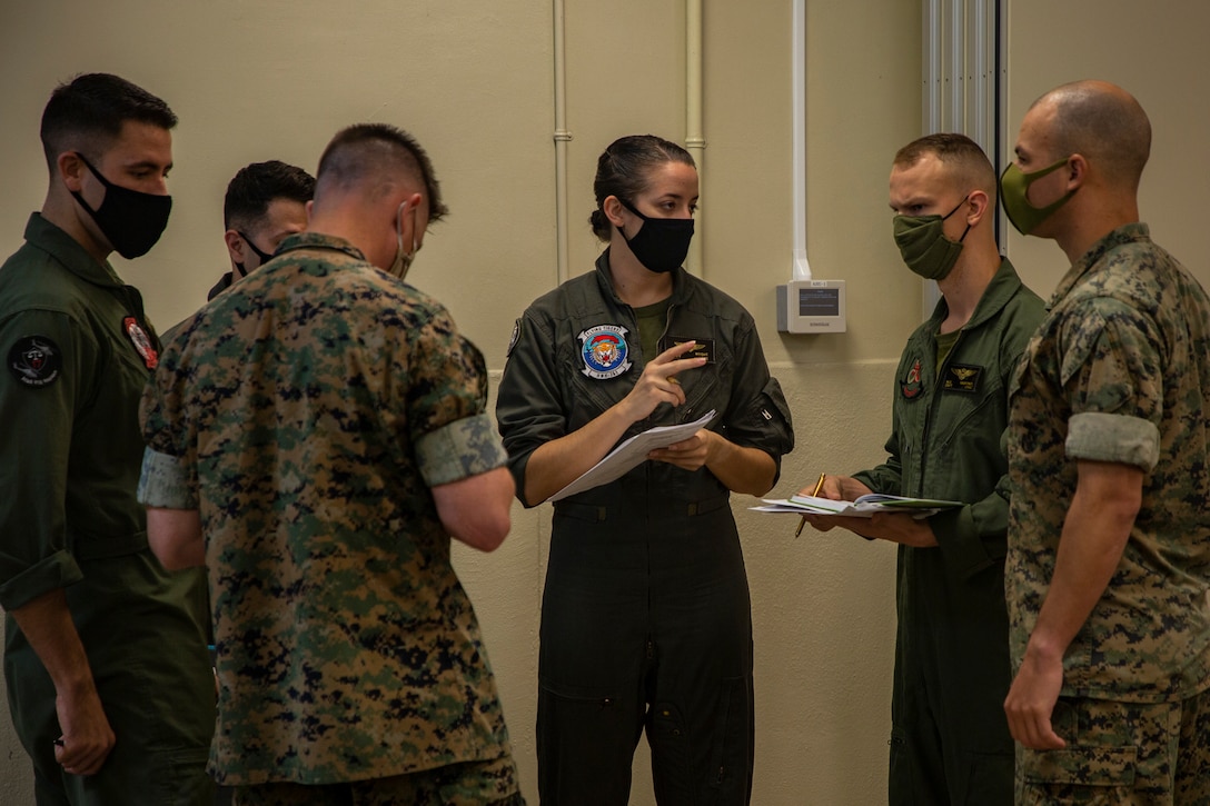 U.S. Marines and Airmen with 1st Marine Aircraft Wing and 33rd Rescue Squadron attend a briefing for the Primer Weapons Tactics Instructors Course exercise, wherein service members will cooperate towards the goal of increasing interoperability and flexibility between U.S. Forces, Marine Corps Air Station Futenma, Okinawa, Japan, Aug. 4, 2020. 1st MAW is committed to readiness in the Indo-Pacific, and continues to train and operate as part of our commitment to providing a strong and capable force to our partners and allies, while adhering to implemented health protection measures. (U.S. Marine Corps photo by Cpl. Ethan M. LeBlanc)