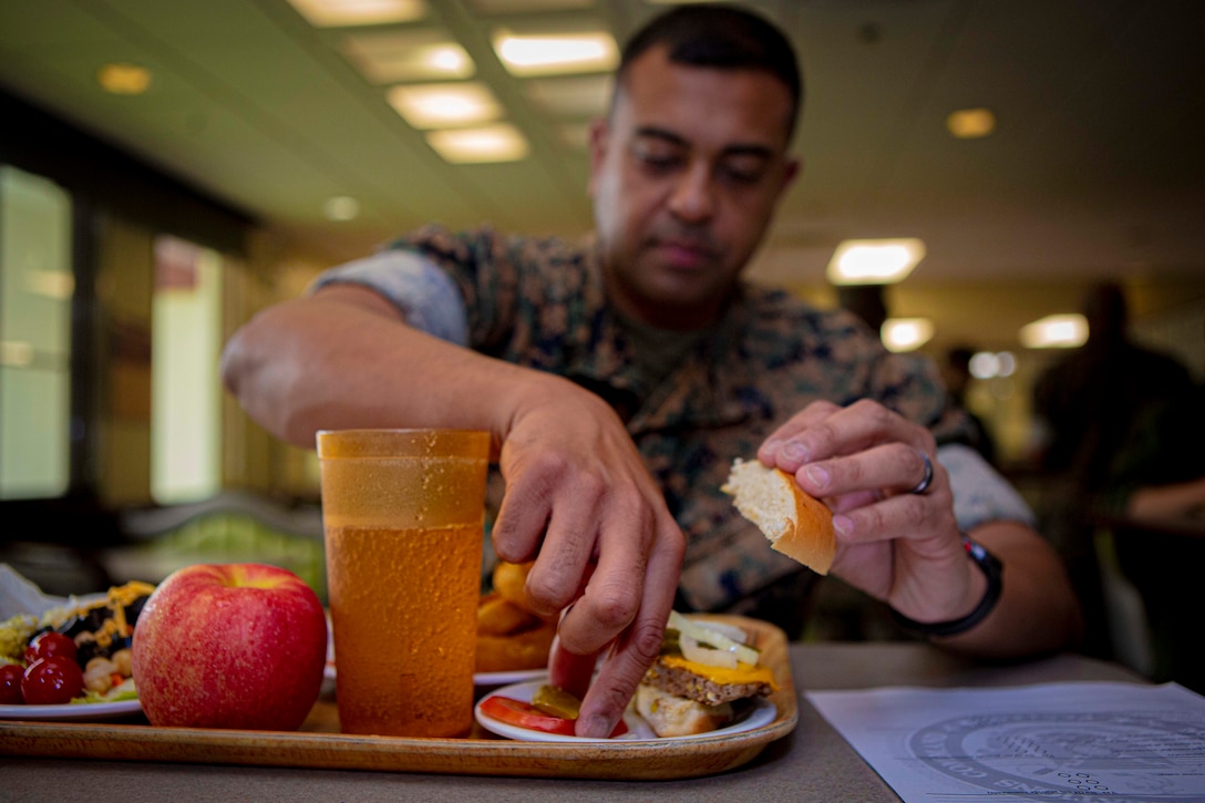 U.S. Marine Corps Staff Sgt. Obaid Halim, an aviation ordnance system technician with 1st Marine Aircraft Wing, tests a new menu item,  May 13, 2020 at Marine Corps Air Station Futenma, Okinawa, Japan. In an effort to be more inclusive of Marines with different lifestyles, MCAS Futenma’s mess hall was the first military dining facility on Okinawa to introduce a plant-based burger to it’s menu. (U.S. Marine Corps photo by Cpl. Christopher A. Madero)