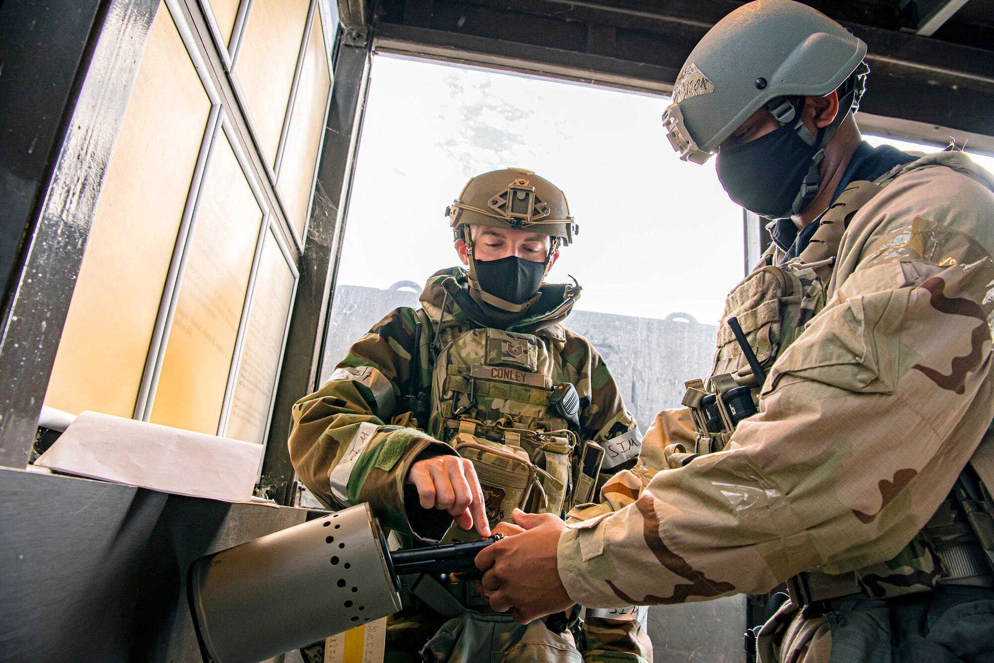 U.S. Air Force Tech. Sgt. Johnny Conley, left, 423rd Security Forces Squadron flight sergeant, assists Staff Sgt. Thaddeus Johnson, 423rd Forces Support Squadron personalist, on clearing his M9 Beretta pistol during a wing readiness exercise at RAF Alconbury, England, Aug. 5, 2020. The 501st Combat Support Wing conducted the exercise to evaluate Airmen’s overall readiness along with their proficiency with responding to simulated chemical, biological, radiological, nuclear and explosive attacks. (U.S. Air Force photo by Senior Airman Eugene Oliver)