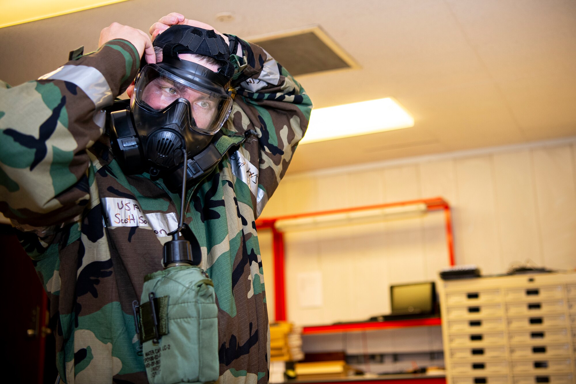 U.S. Air Force Staff Sgt. Scott Sorenson, 423rd Communications Squadron noncommissioned officer in charge of network management, adjusts his gas mask during a wing readiness exercise at RAF Alconbury, England, Aug. 5, 2020. The 501st Combat Support Wing conducted the exercise to evaluate Airmen’s overall readiness along with their proficiency with responding to simulated chemical, biological, radiological, nuclear and explosive attacks. (U.S. Air Force photo by Senior Airman Eugene Oliver)