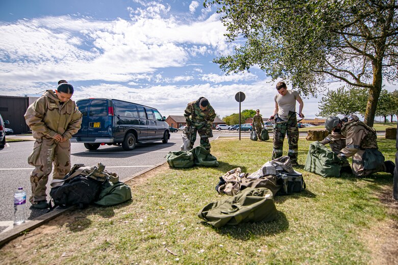 U.S. Air Force Airmen from the 501st Combat Support Wing, put on their mission oriented protective posture gear during a wing readiness exercise at RAF Alconbury, England, Aug. 5, 2020. The 501st CSW conducted the exercise to evaluate Airmen’s overall readiness along with their proficiency with responding to simulated chemical, biological, radiological, nuclear and explosive attacks. (U.S. Air Force photo illustration by Senior Airman Eugene Oliver)