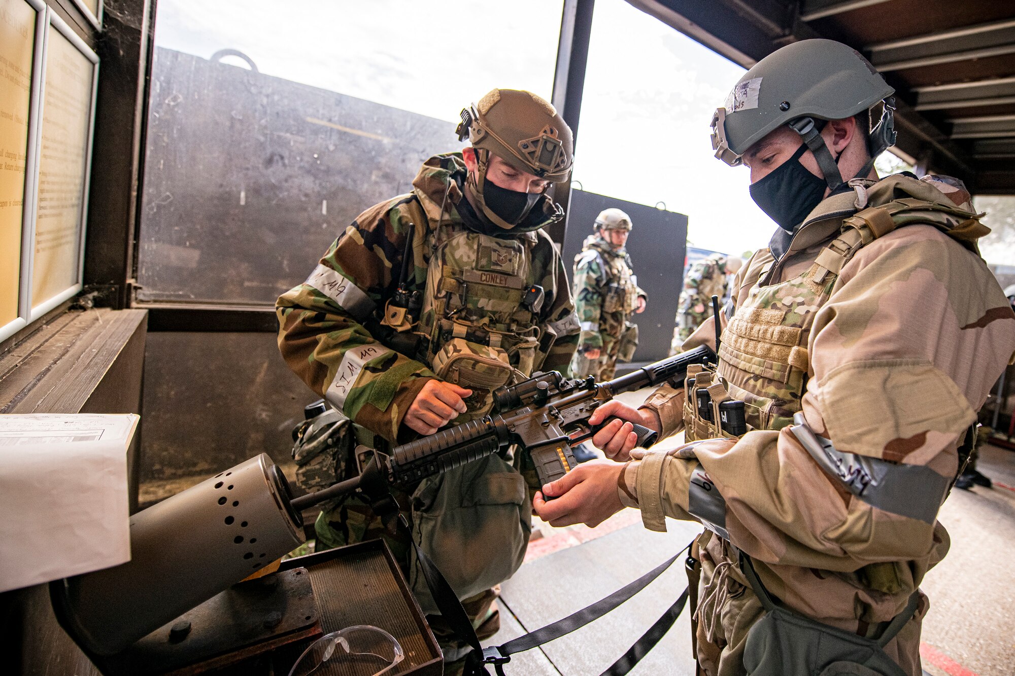 U.S. Air Force Tech. Sgt. Johnny Conley, left, 423rd Security Forces Squadron flight sergeant, helps Senior Airman Kevin Bueno, right, 423rd Communications Squadron focal point technician, with clearing his M4 carbine rifle during a wing readiness exercise at RAF Alconbury, England, Aug. 5, 2020. The 501st Combat Support Wing conducted the exercise to evaluate Airmen’s overall readiness along with their proficiency with responding to simulated chemical, biological, radiological, nuclear and explosive attacks. (U.S. Air Force photo by Senior Airman Eugene Oliver)
