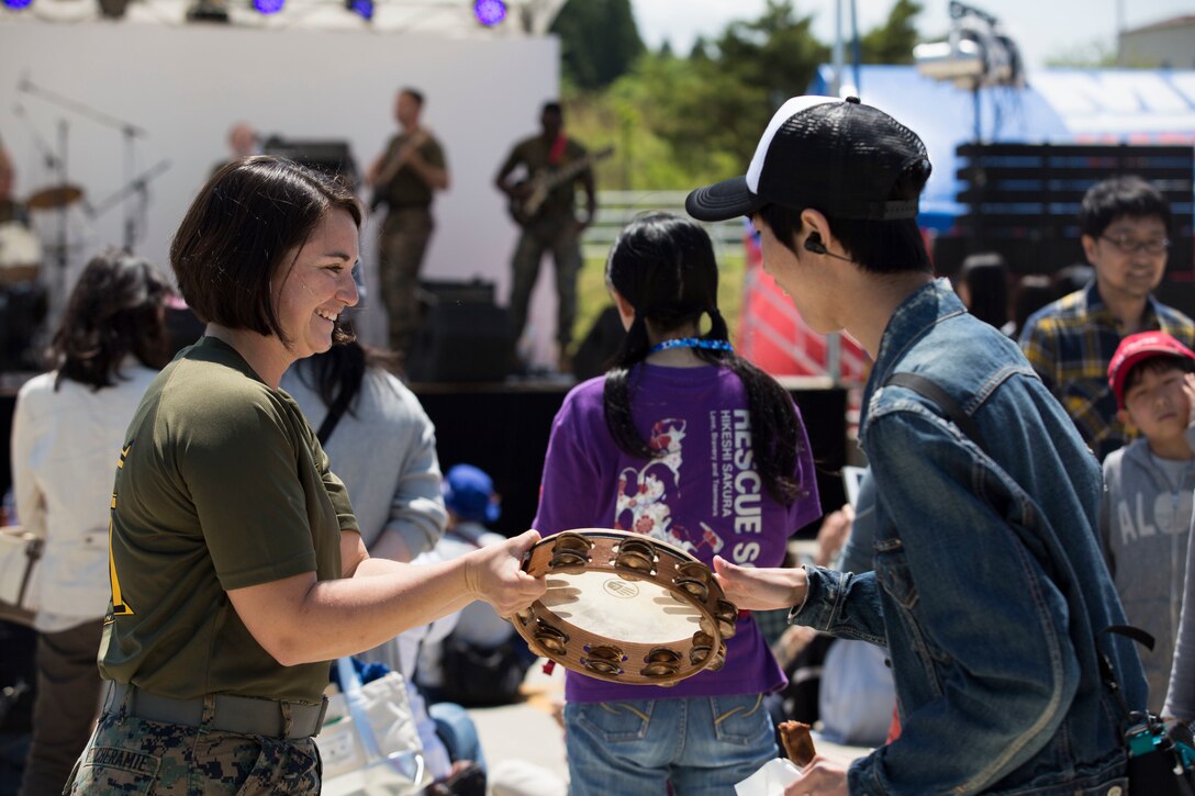 Two people play a tambourine.