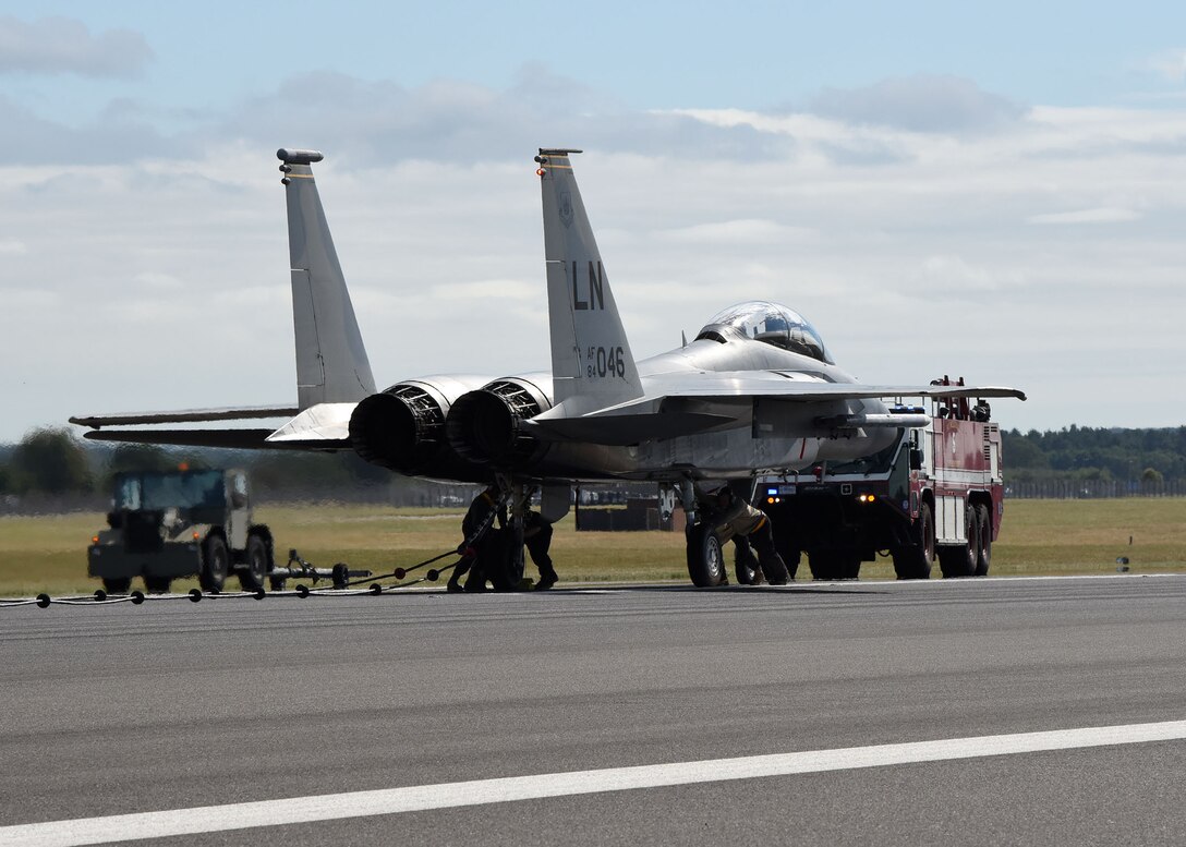 An F-15E Strike Eagle assigned to the 48th Fighter Wing, RAF Lakenheath, sits on the runway after engaging a barrier cable during a certification test of the Mobile Aircraft Arresting System at RAF Mildenhall, England, Aug. 5, 2020. Airmen from the 100th Civil Engineer Squadron Power Production shop removed the cable, which is the most commonly used arresting system in the U.S. Air Force. This model of the MAAS has been in service since 1971 and was used during the Vietnam War. (U.S. Air Force photo by Karen Abeyasekere)