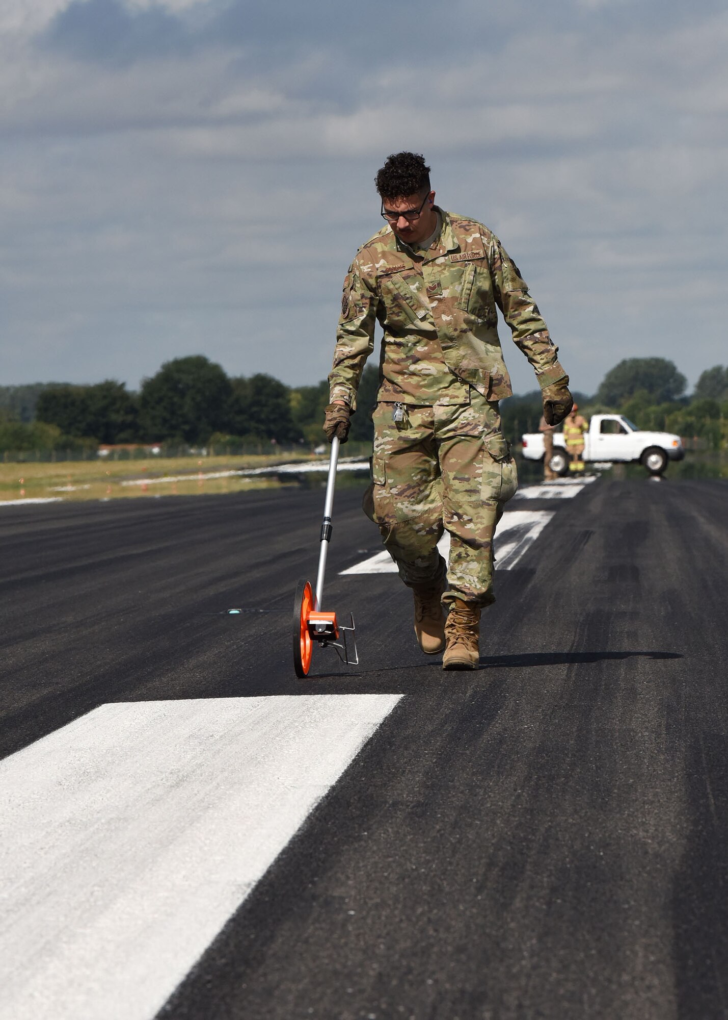 Staff Sgt. Erik Rosales, 100th Civil Engineer Squadron Power Production craftsman measures the distance the Mobile Aircraft Arresting System took to stop an F-15E Strike Eagle from the 48th Fighter Wing, RAF Lakenheath, on RAF Mildenhall, England, Aug. 5, 2020. The 100th CES Power Production Airmen worked with the fire department during the MAAS certification process. (U.S. Air Force photo by Karen Abeyasekere)