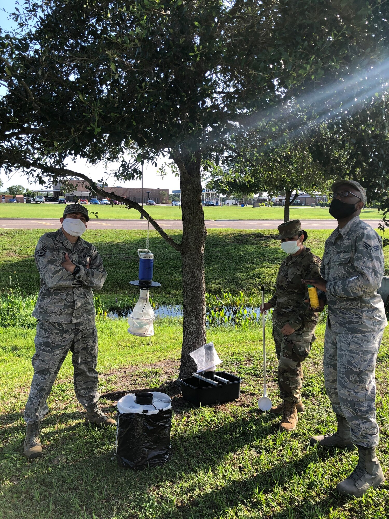 From left, Staff Sgt. Jeffery Segal, Airman 1st Class Jenisha Shakal, and Senior Airman Brandon Cobb, 6th Operational Medical Readiness Squadron public health technicians, set up mosquito surveillance equipment at MacDill Air Force Base, Florida.
