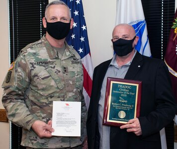 Maj. Gen. Dennis P. LeMaster, commanding general of the U.S Army Medical Center of Excellence at Joint Base San Antonio-Fort Sam Houston, presents Robert “Bob” Preshong, Department of Combat Medic Training, with the U.S. Army Training and Doctrine Command, or TRADOC, Civilian Instructor of the Year award and a letter from Gen. Paul E. Funk II, TRADOC commanding general.