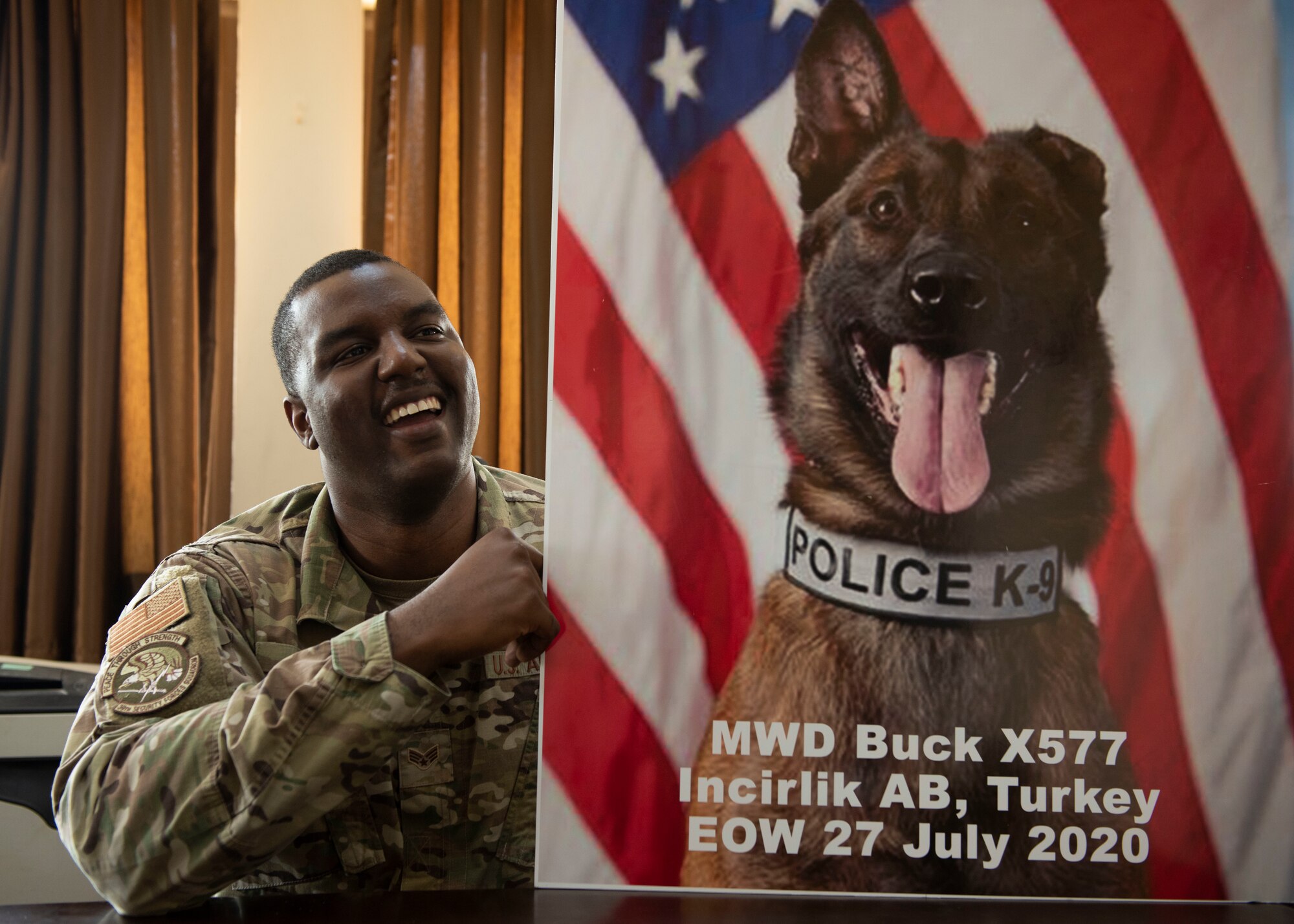 U.S. Senior Airman Antoine Carr talks about his time working with MWD Buck while holding up Buck's memorial poster Aug. 5, 2020, at Incirlik Air Base, Turkey.