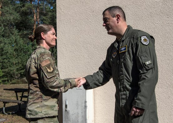 U.S. Air Force Tech. Sgt. Amber Coronado, 86th Airlift Wing Judge Advocate noncommissioned officer in charge of adverse actions, left, receives a coin from Brig. Gen. Mark R. August, 86th Airlift Wing commander, after being named Airlifter of the Week at Ramstein Air Base, Germany, July 31, 2020.