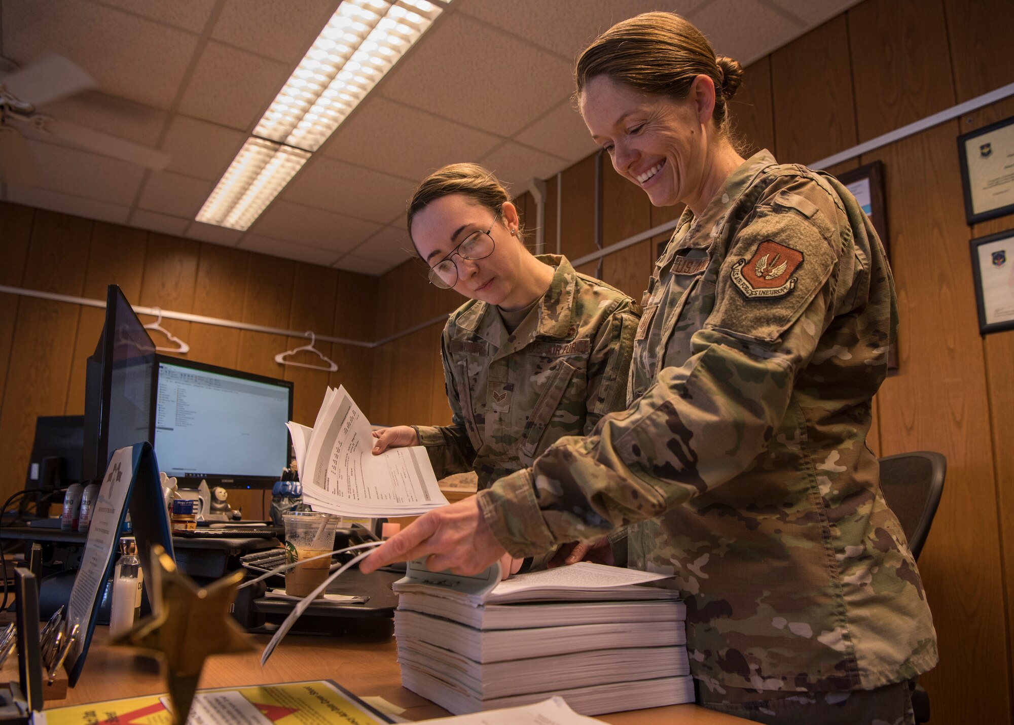U.S. Air Force Tech. Sgt. Amber Coronado, 86th Airlift Wing Judge Advocate noncommissioned officer in charge of adverse actions, right, and Senior Airman Katrina Walter, 86th AW JA military justice paralegal, look through documents at Ramstein Air Base, Germany, Aug 4, 2020.