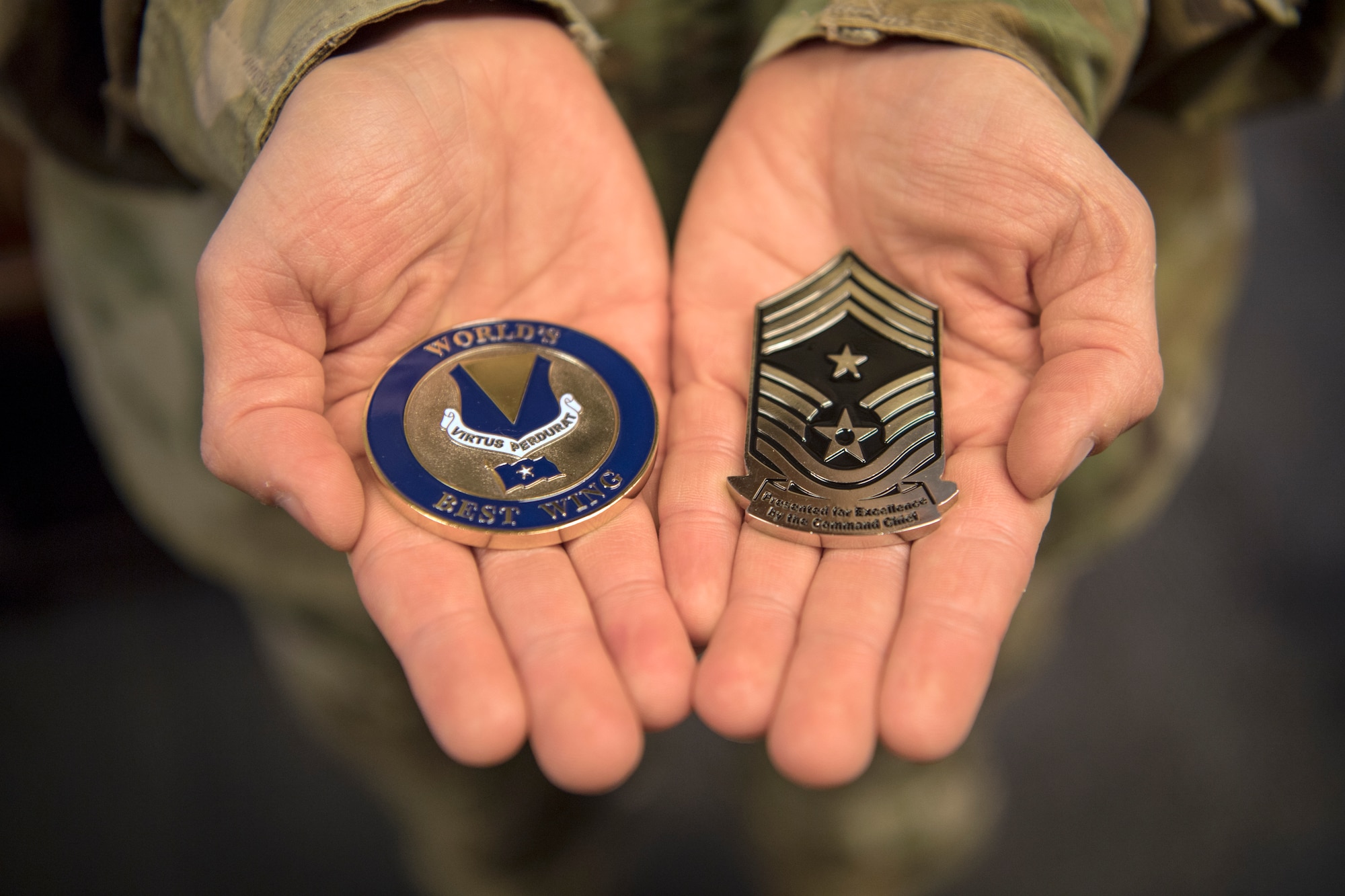 U.S. Air Force Tech. Sgt. Amber Coronado, 86th Airlift Wing Judge Advocate noncommissioned officer in charge of adverse actions, holds coins presented by the base commander and command chief for being Airlifter of the Week at Ramstein Air Base, Germany, Aug. 4, 2020.