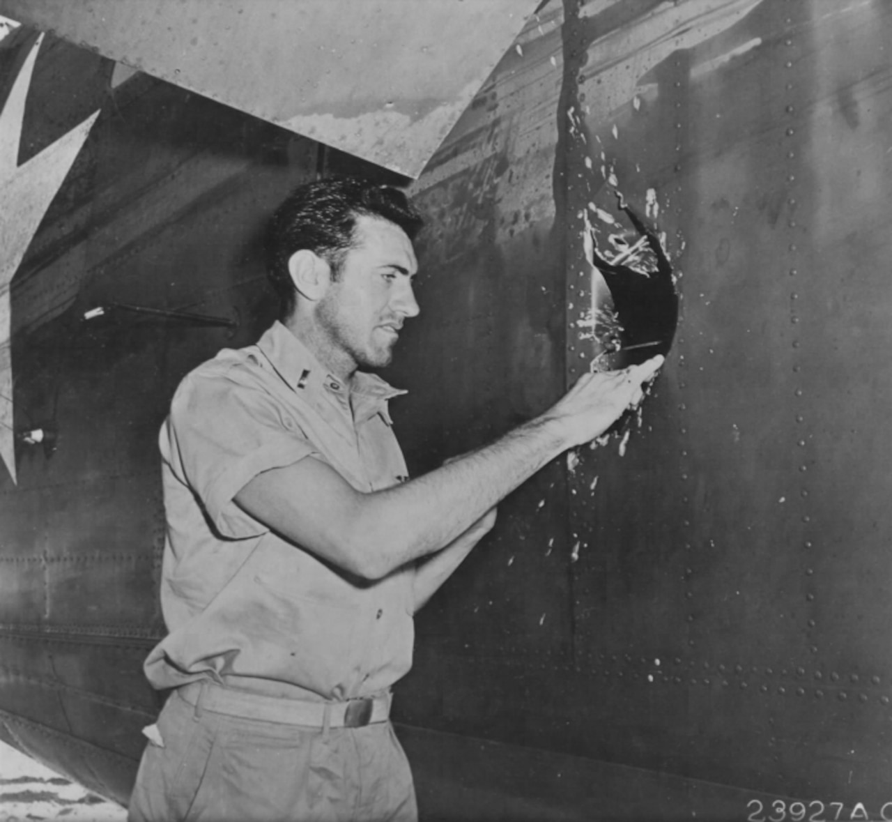 Man looks at a hole in an airplane.