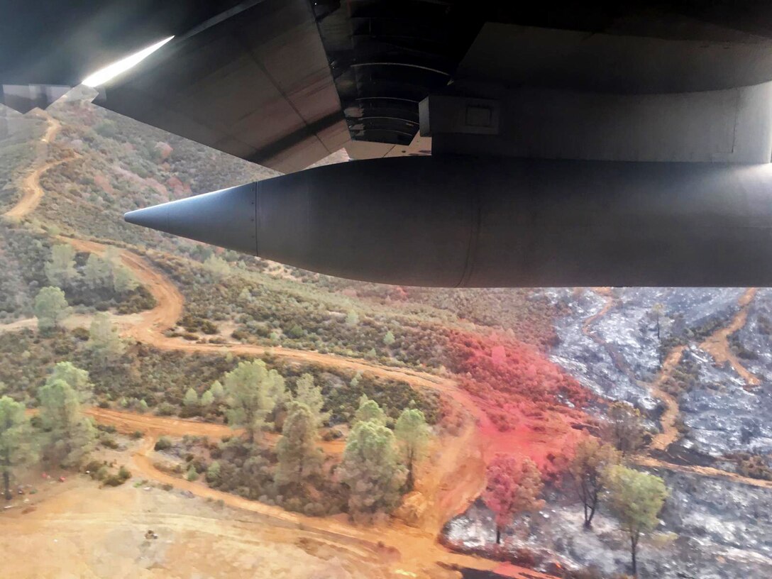 Large military aircraft flies over fires in California.