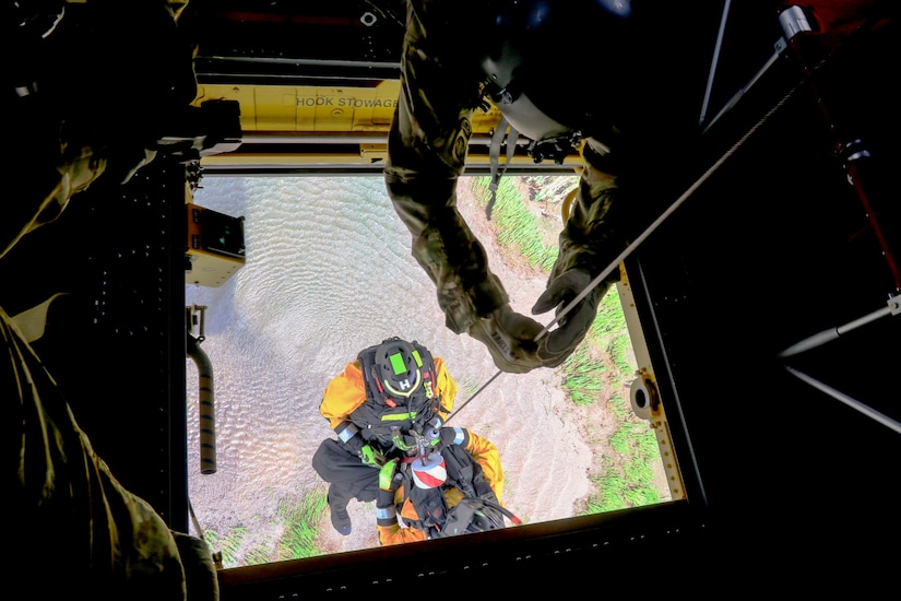 Pennsylvania National Guard members joined with partners in the Helicopter Aquatic Rescue Team (PA-HART) and other civilian first responders in a full-scale exercise at Fort Hunter Park and the Susquehanna River Aug. 15. A Guard member lowers a HART technician through the center hoist to retrieve a simulated casualty. (U.S. Army National Guard photo by Staff Sgt. Zane Craig)