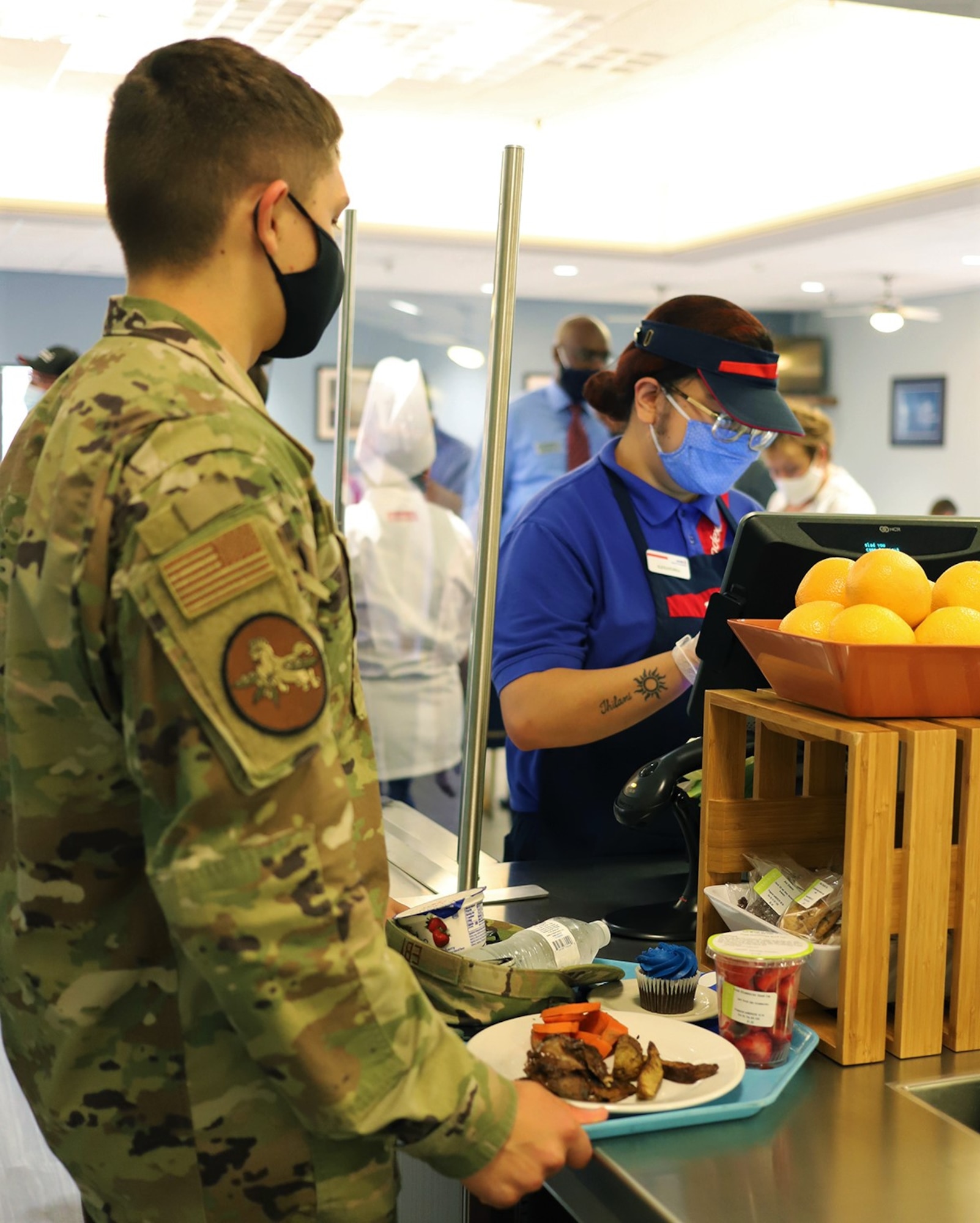 A Sodexo employee enters in a student’s lunch at the newly reopened The Beachcombers dining facility at Vandenberg AFB, California, Aug. 6, 2020.