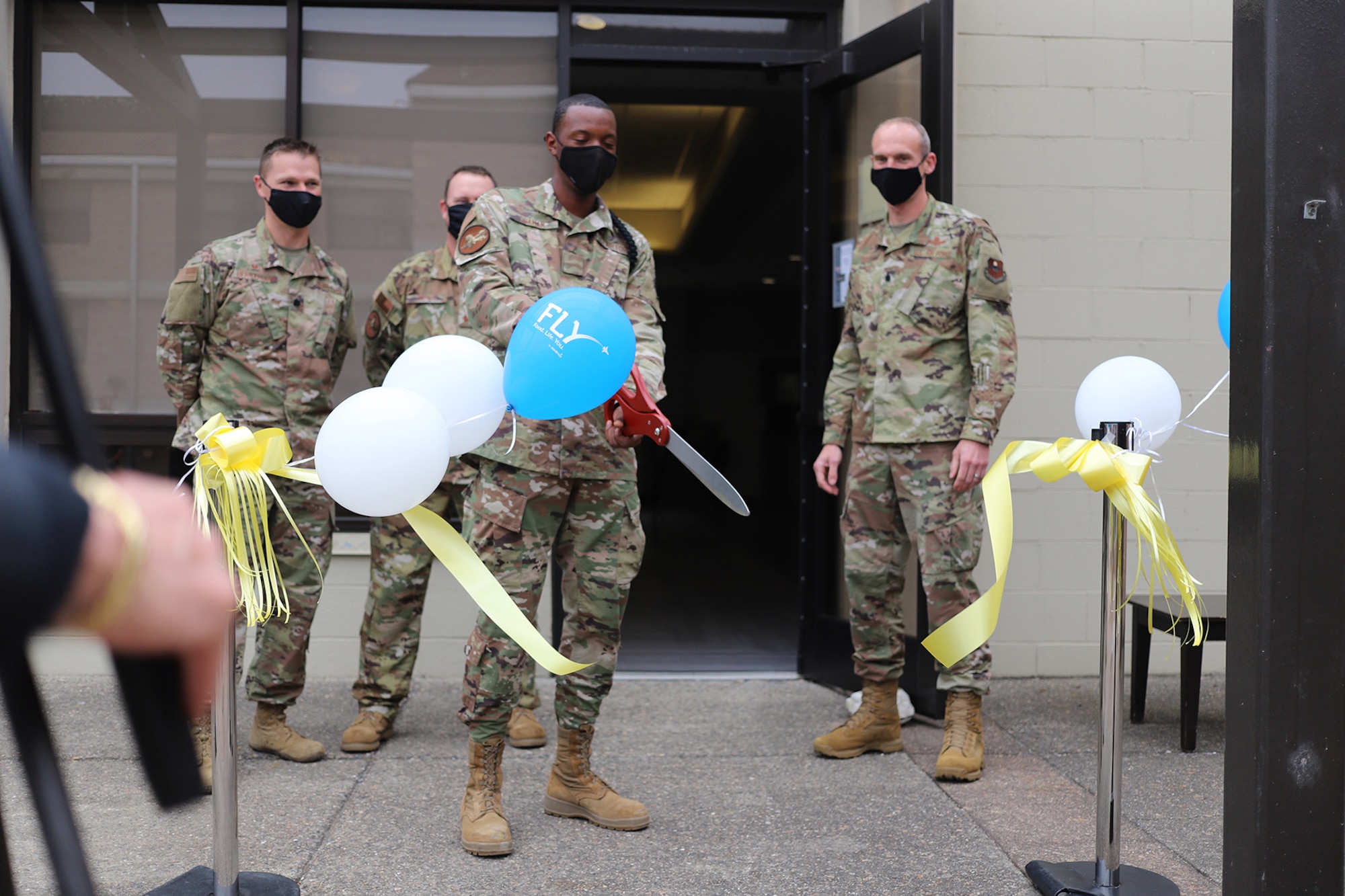 A 381st Training Group student cuts the ribbon to officially reopen The Beachcombers dining facility at Vandenberg AFB, California, Aug. 6, 2020.