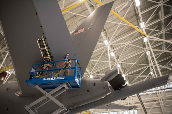 Airman 1st Class Joshua Tillman, 22nd Maintenance Squadron crew chief, assists Airman 1st Class Francisco Ramirez, 22nd Maintenance Squadron crew chief, with a 4A-check on a KC-46 Pegasus Aug. 3, 2020, at McConnell Air Force Base, Kansas. Tillman and Ramirez removed the panels to access the flight control actuators for a visual inspection and to lubricate all the mechanical components. (U.S. Air Force photo by Senior Airman Alexi Bosarge)