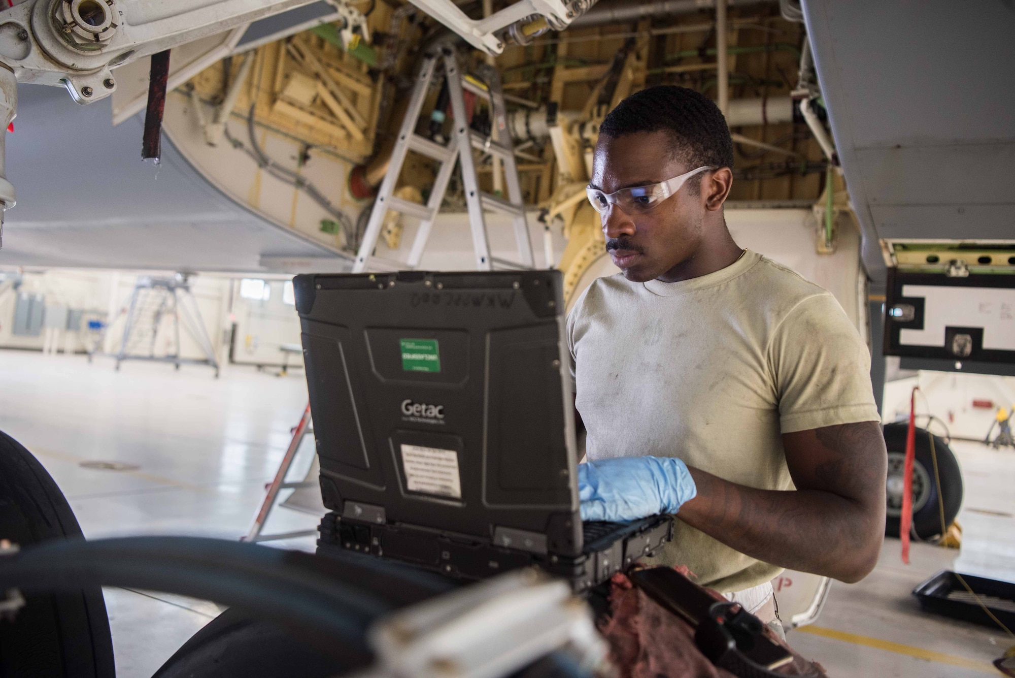 Airman 1st Class Jonethen Strickland, 22nd Maintenance Squadron crew chief, reads a technical order while working the main landing gear door on a KC-46A Pegasus Aug. 3, 2020, at McConnell Air Force Base, Kansas. Technical orders provide a step-by-step process for Airmen to complete maintenance tasks. (U.S. Air Force photo by Senior Airman Alexi Bosarge)