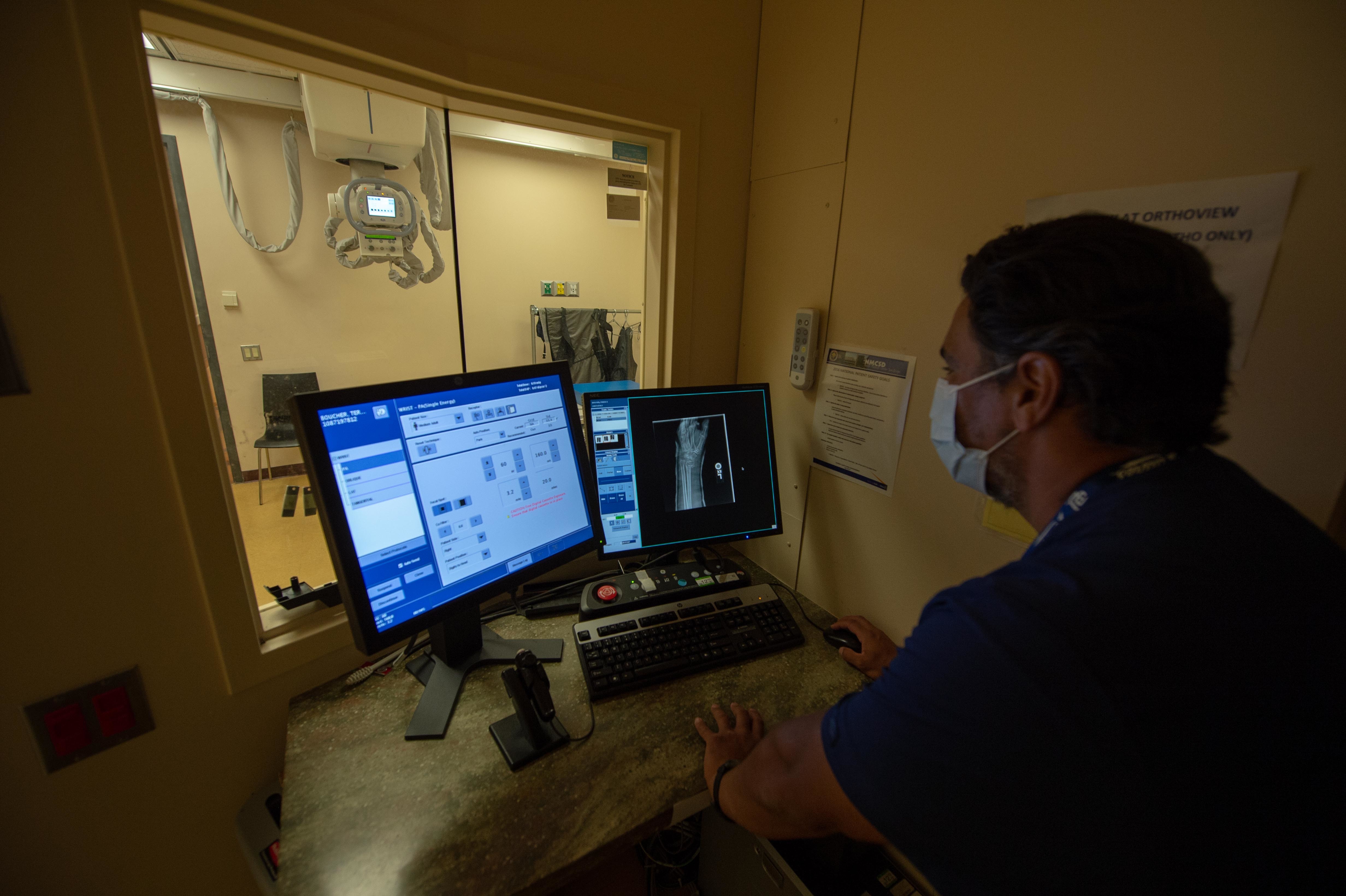 Kasey Kirchner, a radiology technician assigned to Naval Medical Center San Diego (NMCSD), reviews patient's X-ray in the hospital's Orthopedics Clinic Aug. 5.