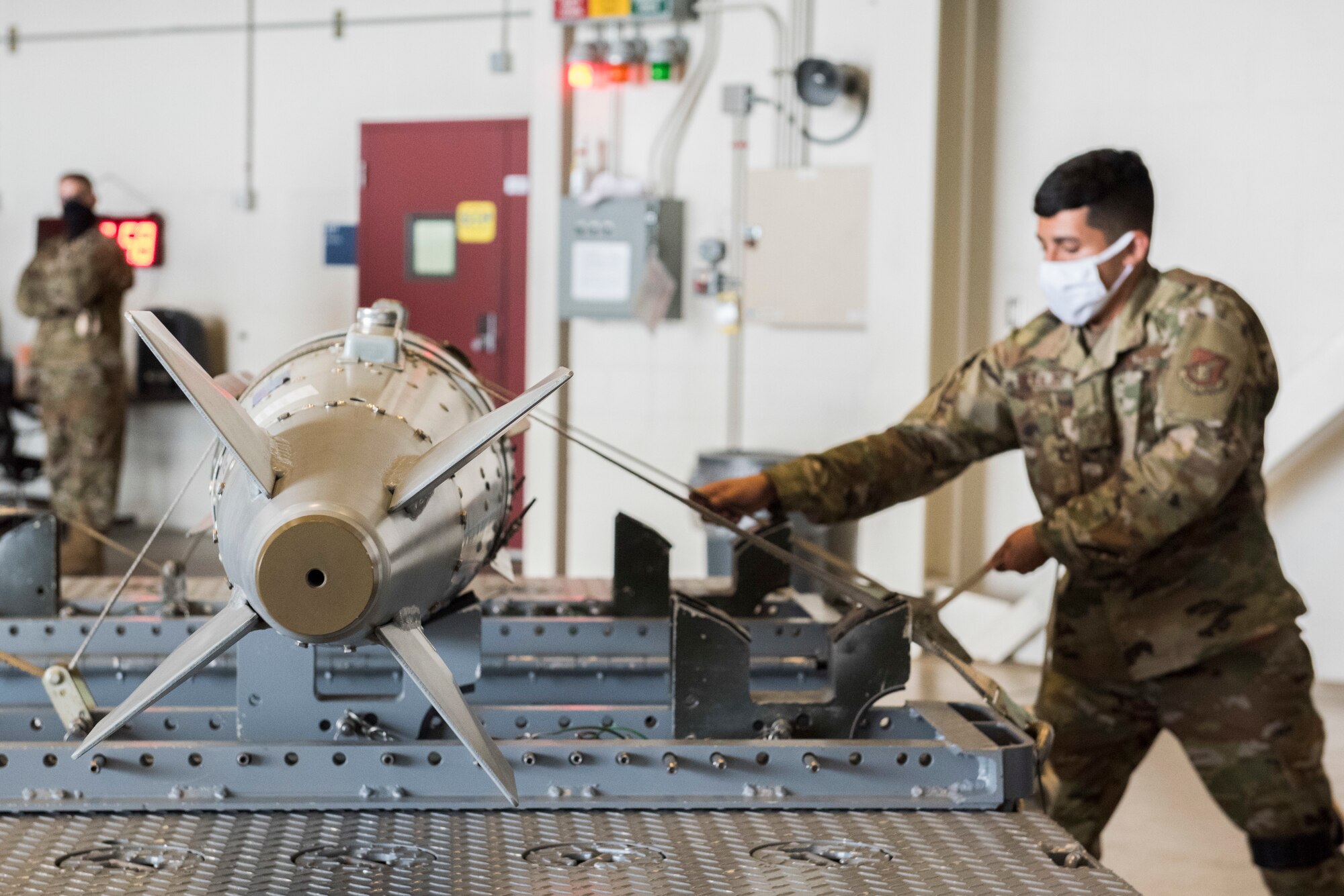 U.S. Air Force Airman 1st Class Aaron Aguilar, 90th Maintenance Unit weapons crew member, tightens the straps on a GBU-32 Joint Direct Attack Munition during the 2nd Quarterly Wing Load Crew competition at Joint Base Elmendorf-Richardson, Alaska, July 31, 2020. The event consisted of the 90th AMU and 525th AMU testing their technical expertise with a basic knowledge test, composite tool kit inspection, uniform inspection, and F-22 weapons load out.