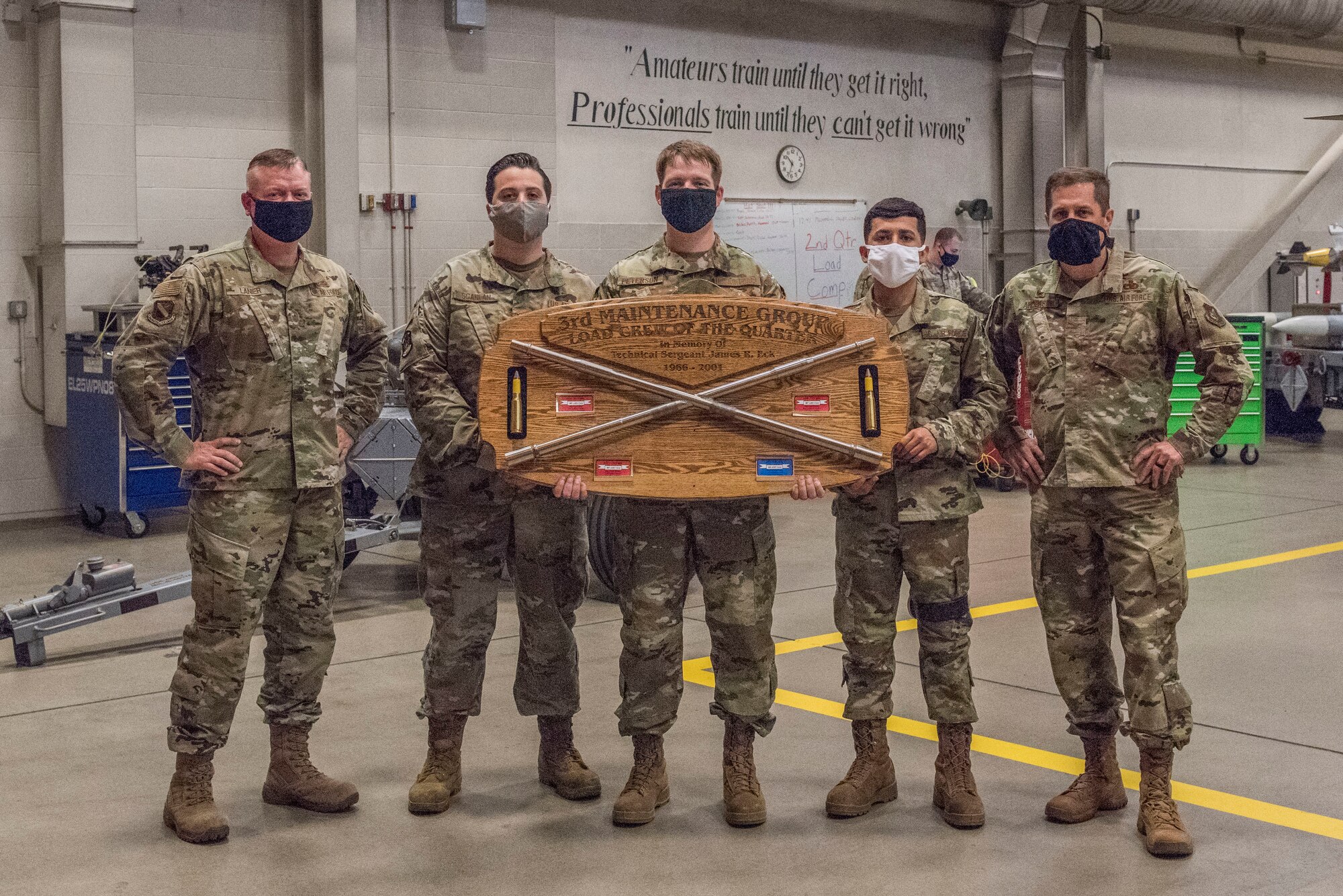 U.S. Air Force Chief Master Sgt. Spencer Lanier, 3rd Maintenance Group weapons standardization superintendent, left, stands with the 525th Aircraft Maintenance Unit weapons load crew, and Air Force Col. Steven Anderson, 3rd MXG commander, following the 2nd Quarterly Wing Load Crew competition at Joint Base Elmendorf-Richardson, Alaska, July 31, 2020. The event consisted of the 90th AMU and 525th AMU testing their technical expertise with a basic knowledge test, composite tool kit inspection, uniform inspection, and F-22 weapons load out.