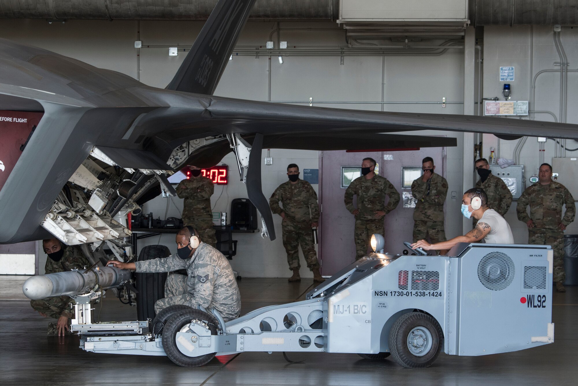 U.S. Air Force Airman 1st Class Richard Grant, 525th Aircraft Maintenance Unit weapons load crew member, guides an AIM-120 Advanced Medium Range Air-to-Air to an Air Force F-22 Raptor with assistance from Air Force Staff Sgt. Laurenzo Singleton, 525th Aircraft Maintenance Unit weapons load crew chief, during the 2nd Quarterly Wing Load Crew competition at Joint Base Elmendorf-Richardson, Alaska, July 31, 2020. The event consisted of the 90th AMU and 525th AMU testing their technical expertise with a basic knowledge test, composite tool kit inspection, uniform inspection, and F-22 weapons load out.
