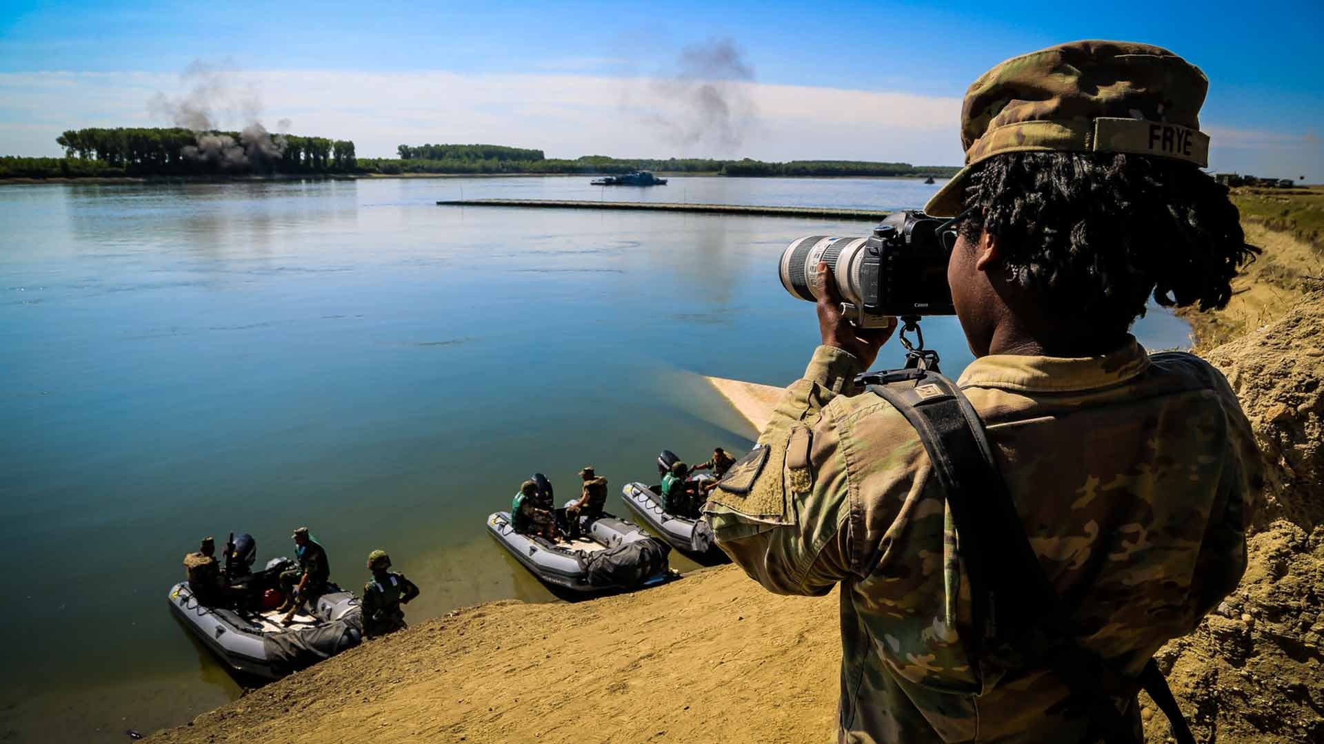 U.S. Army Private First Class Shekinah Frye, photographer assigned to 55th Signal Company (Combat Camera), documents a river crossing exercise during Saber Guardian 17 over the Danube River, Bordusani, Romania, July 15, 2017