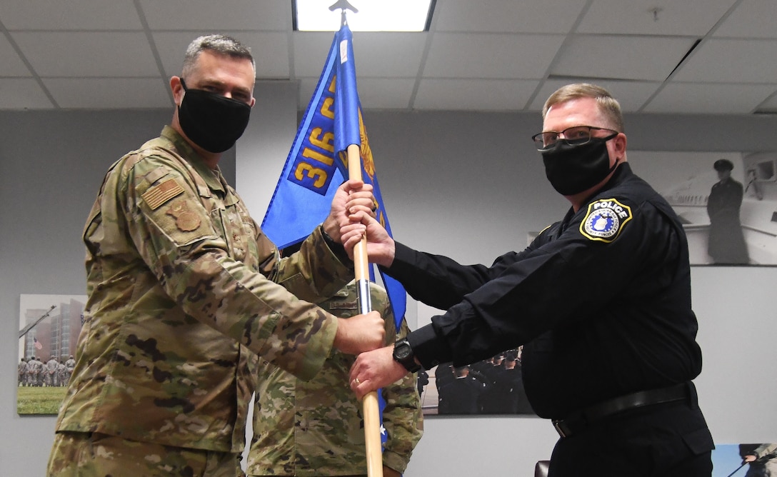 Col. Ian Dinesen, 316th Security Forces Group commander, passes the guidon to Stephen A. Hubbard Jr., who assumed command of the 316th Security Support Squadron during a change of command ceremony at Joint Base Andrews, Md., Aug. 7, 2020.