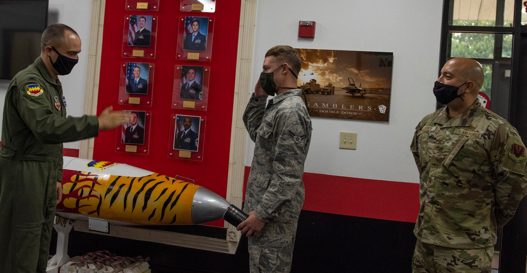 Image of an Airman accepting a Weasel of the Week award.