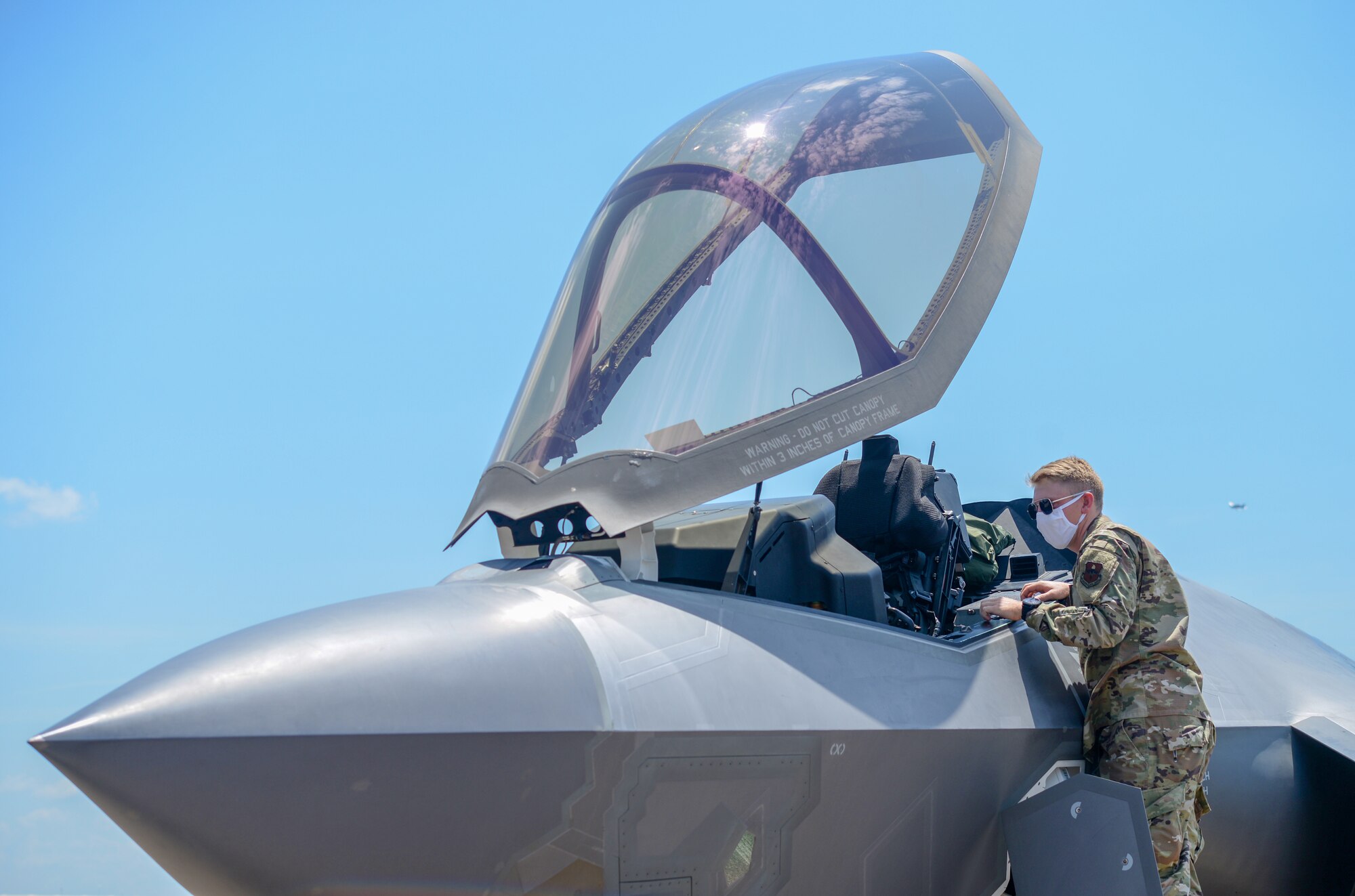 An Airman assigned to the14th Flying Training Wing looks at the interior of an F-35A Lightning II on August 7, 2020 at Columbus Air Force Base, Miss.  With its aerodynamic performance and advanced integrated avionics, the F-35A will provide next-generation stealth, enhanced situational awareness and reduced vulnerability for the United States and allied nations. (U.S. Air Force photo by Airman 1st Class Davis Donaldson)