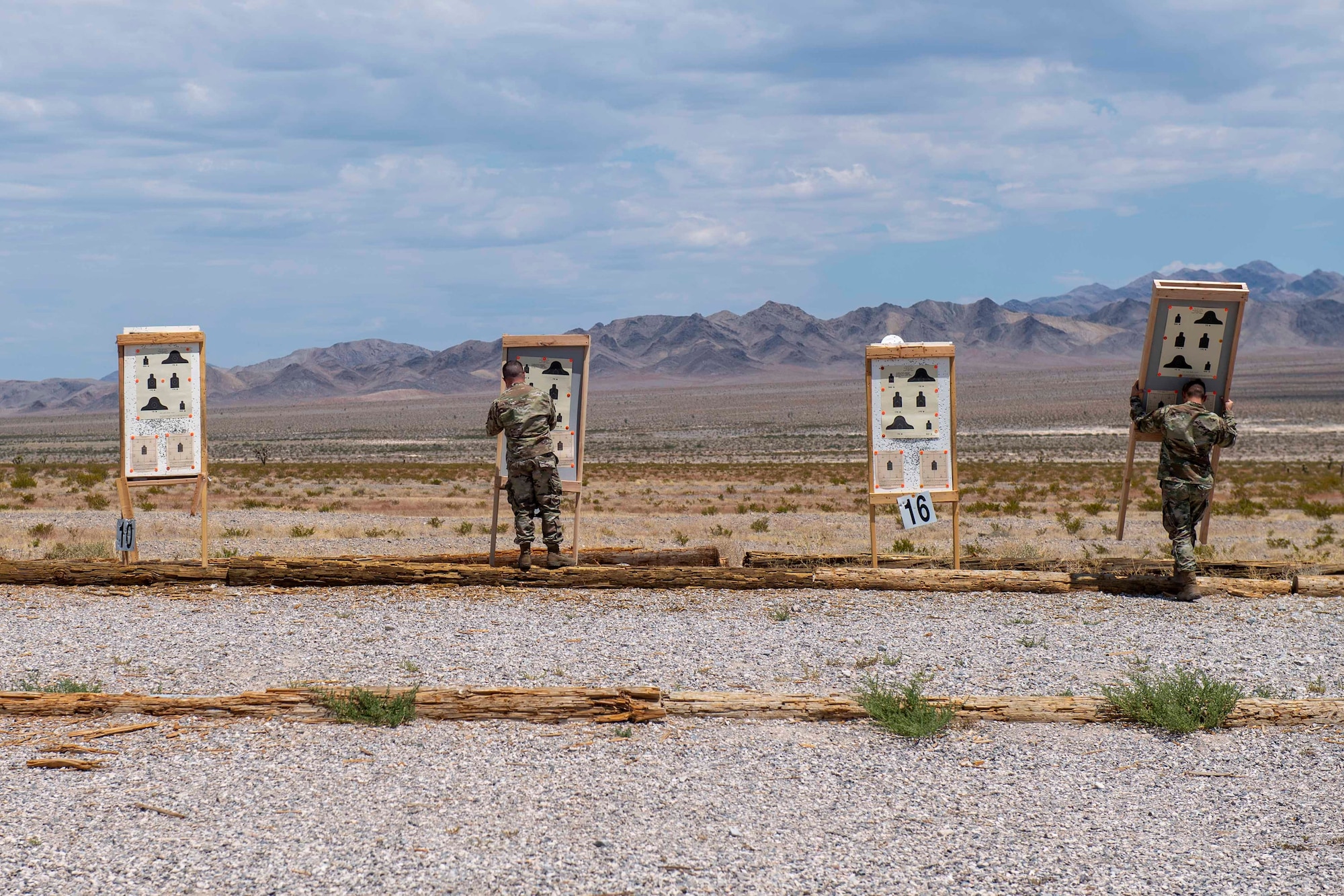 Two male Airmen set up targets on the range