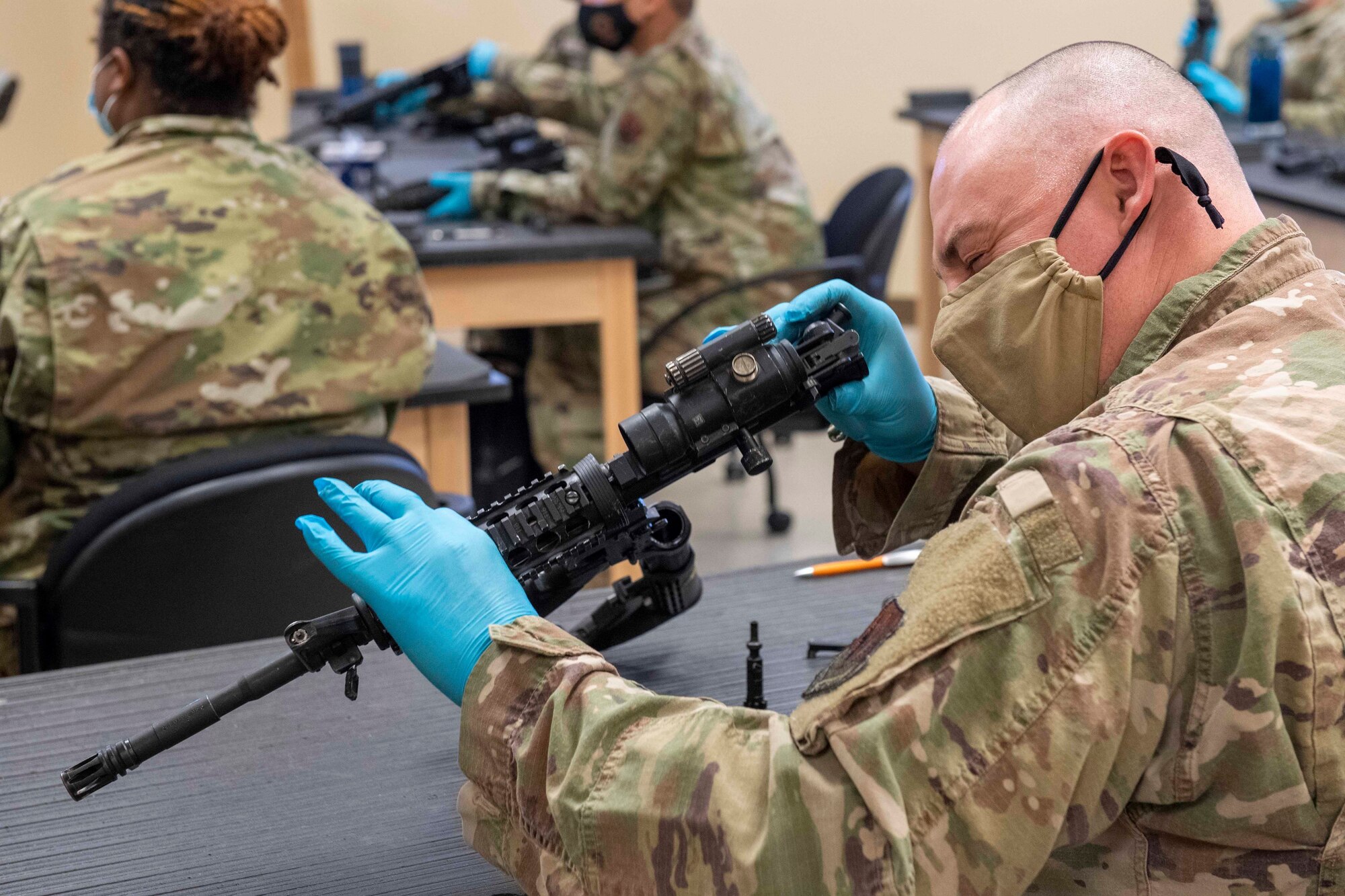 Airman examines the barrel of an M4 carbine