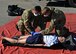 A photo of two Davis-Monthan Air Force Base fire department members providing medical treatment on a mannequin with simulated injuries