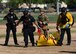 A photo of Davis-Monthan Air Force Base security forces and fire department members dragging a mannequin, simulating an injured person, to safety after an active shooter training exercise.