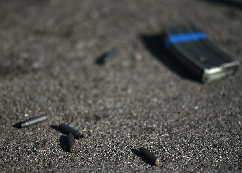 A photo of blank rounds of ammunition with a gun magazine laying on road