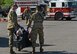 A photo of two Davis-Monthan Air Force Base fire department Airmen carrying a simulated injured mannequin to safety