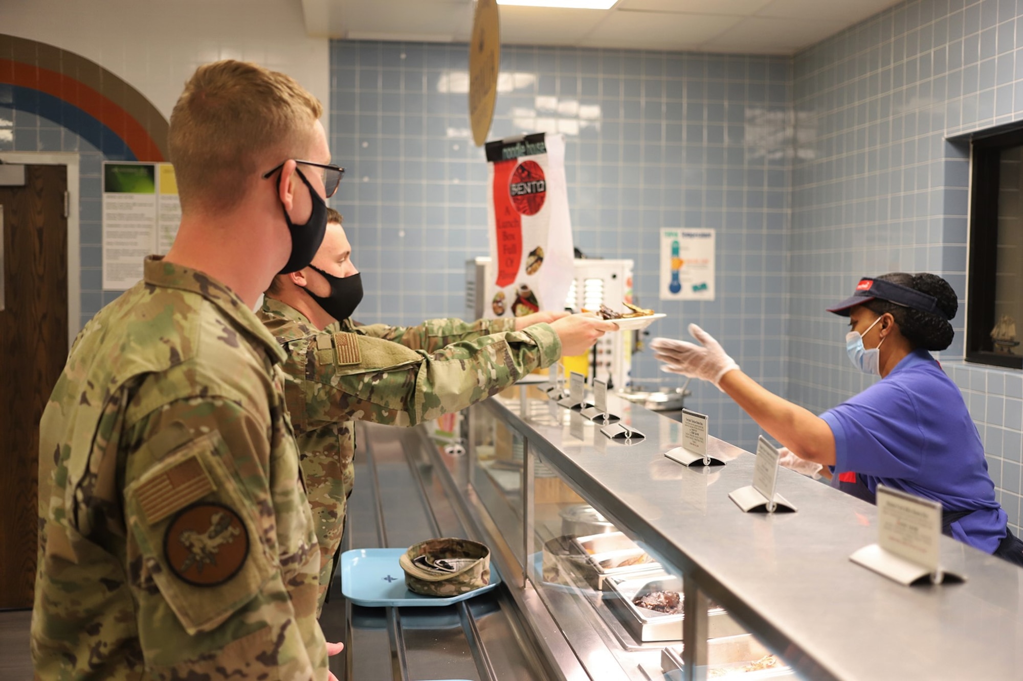 A student receives his lunch at the newly reopened The Beachcombers dining facility at Vandenberg AFB, California, Aug. 6, 2020.