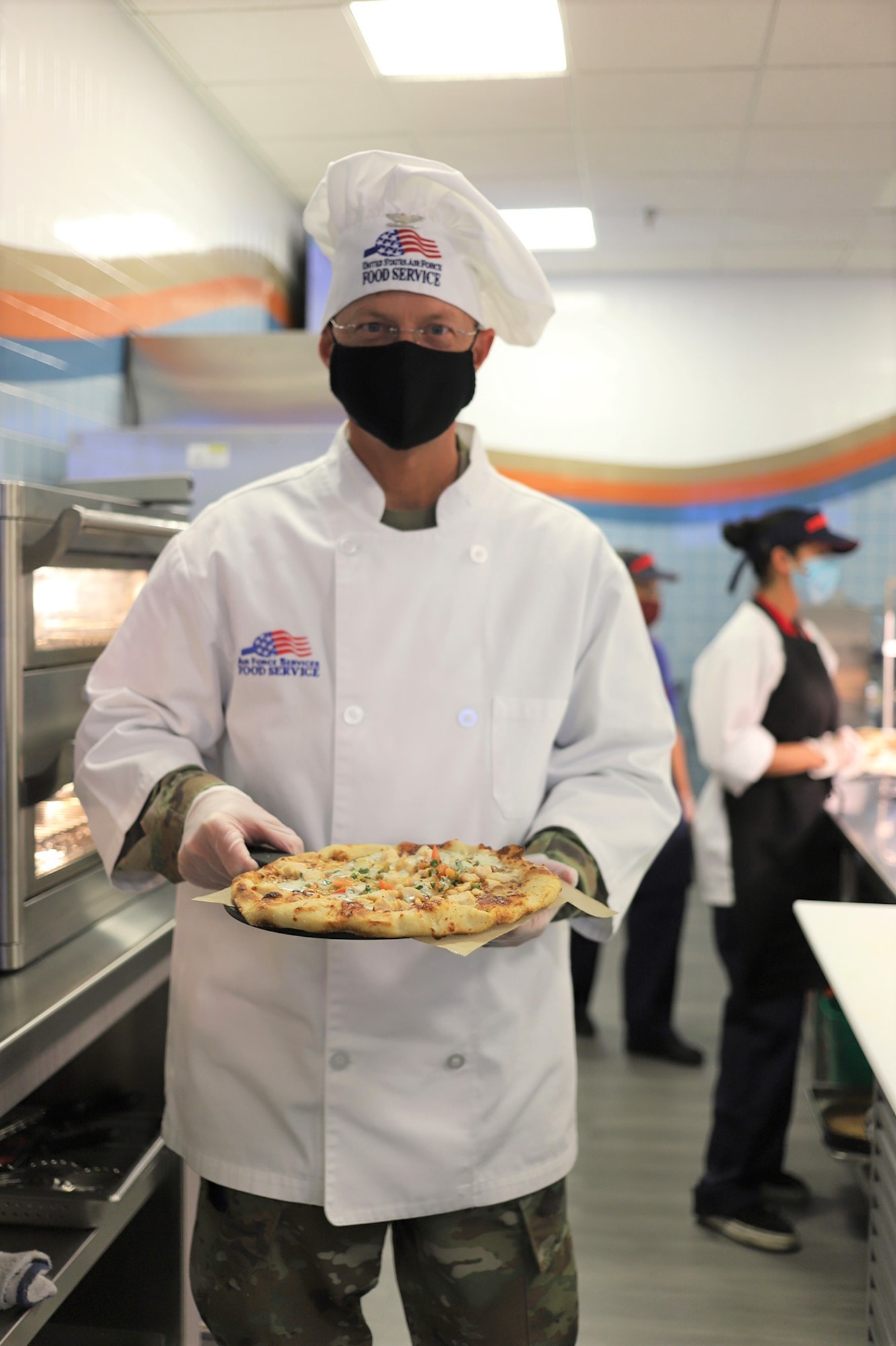 Col. David Rickards, 381st Training Group Commander, is ready to put a freshly cooked pizza on a serving station in the newly reopened The Beachcombers dining facility at Vandenberg AFB, California, Aug. 6, 2020.